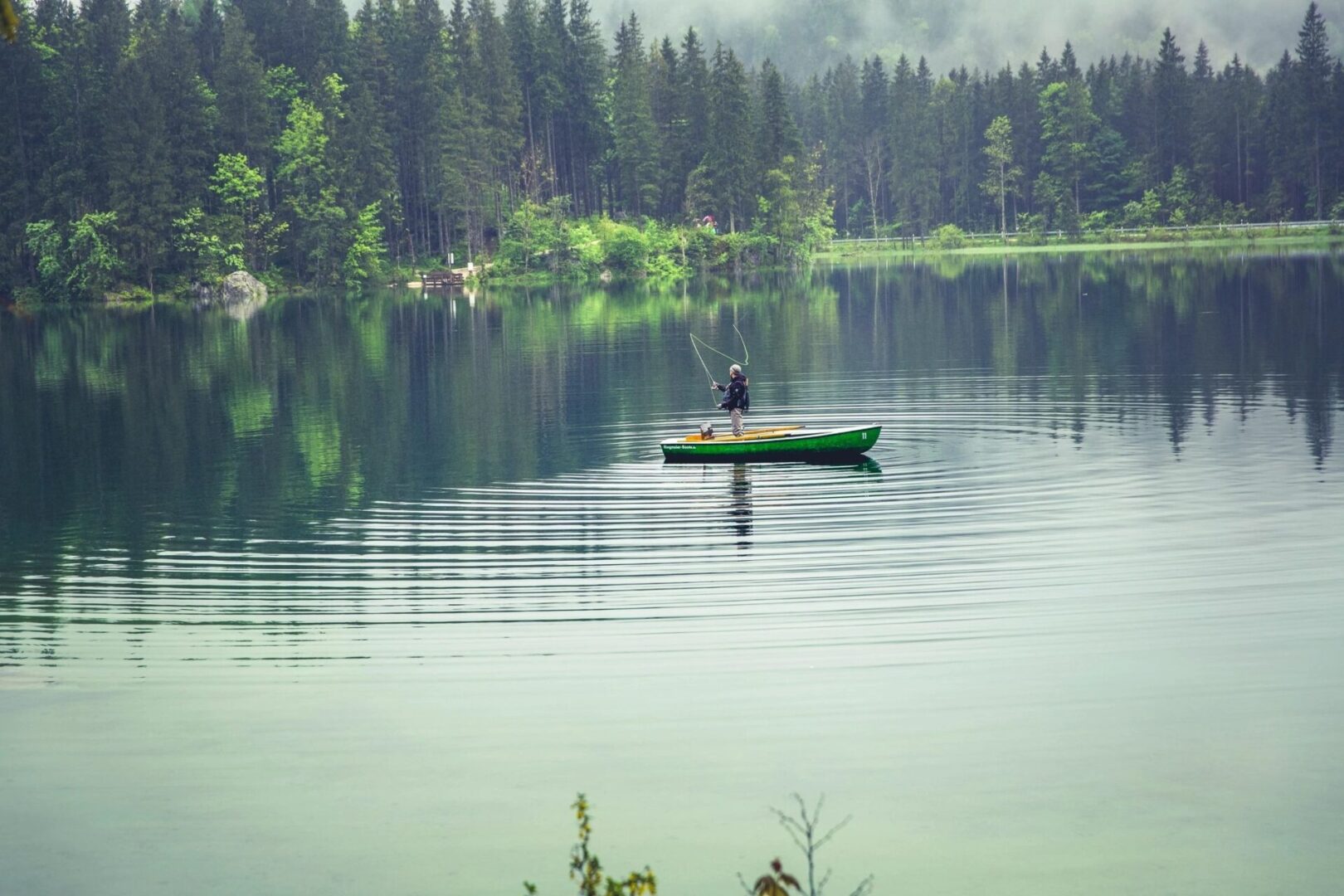 A person in a green boat on the water.