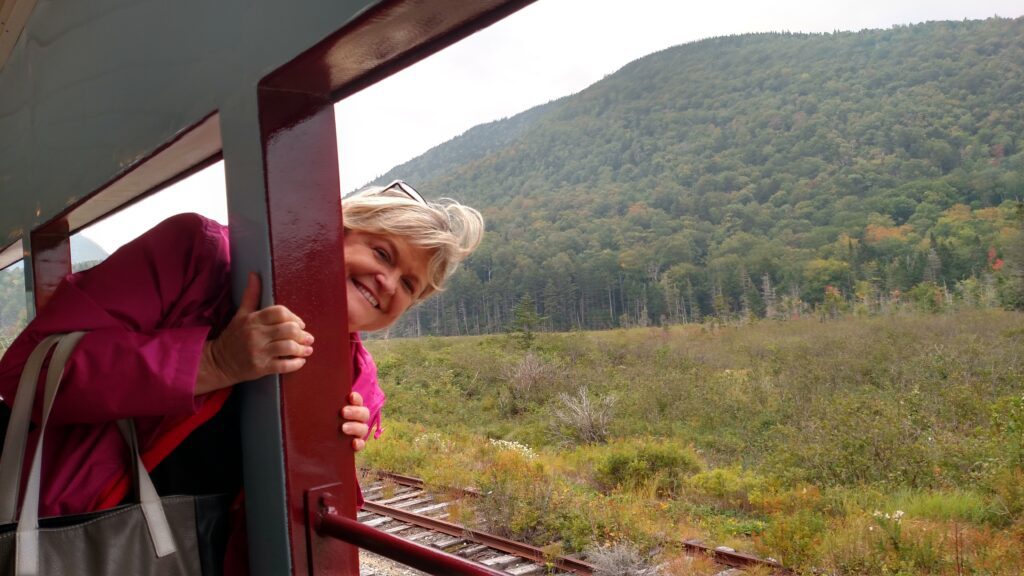 A woman leaning out of the window on a train.