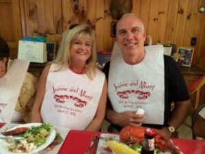 A man and woman sitting at a table with plates of food.