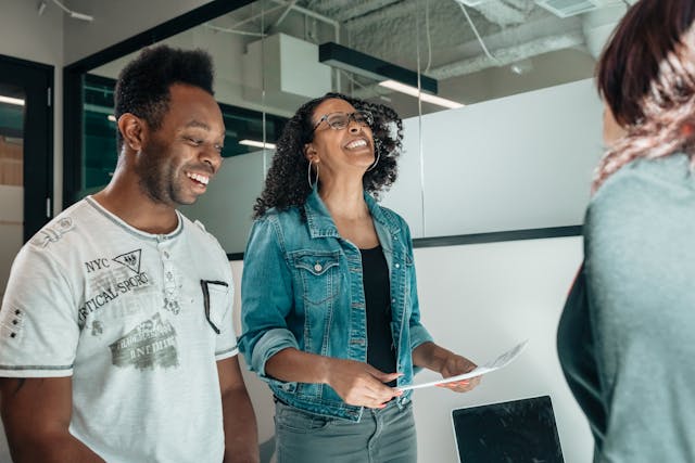 Two colleagues sharing a light moment during a meeting.