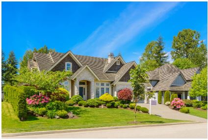 Beautiful suburban house with manicured lawn and clear blue sky.