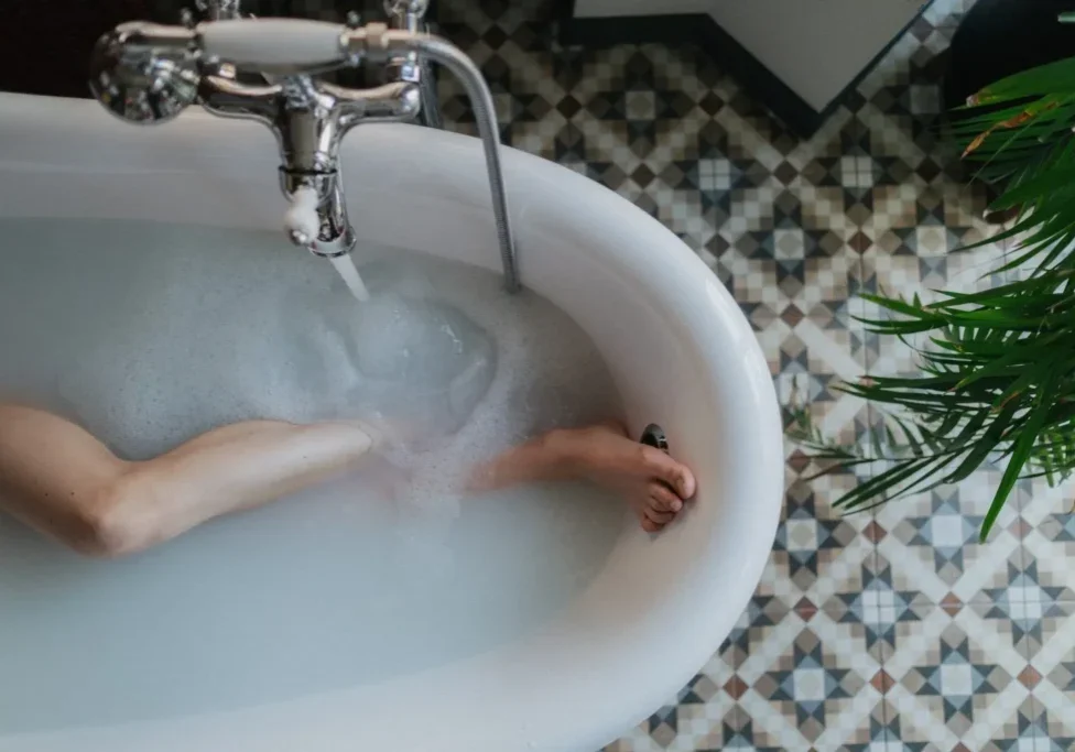A person in the tub with their hand on top of it.