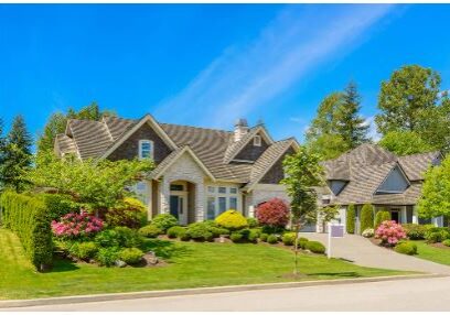 Beautiful suburban house with manicured lawn and clear blue sky.